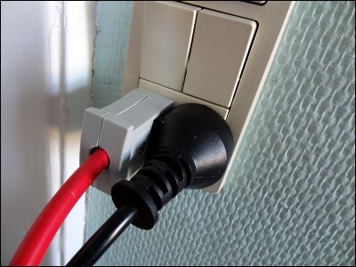 2-polet flad stikprop (dka 2-1b) og rund stikprop side om side i en dobbelt dansk stikkontakt.